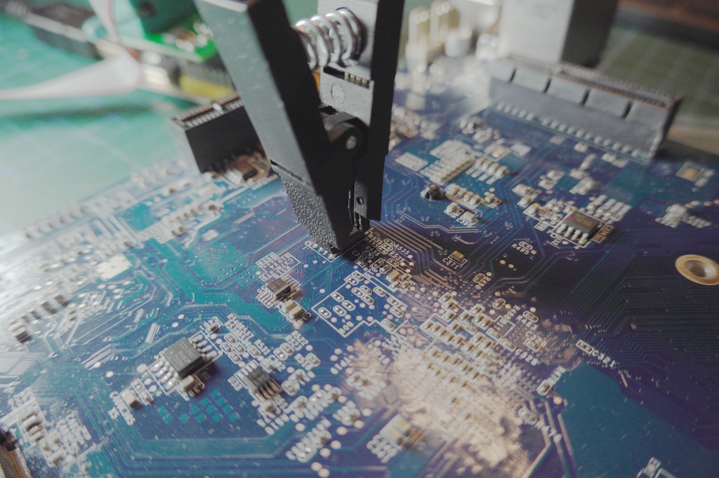 Clipped onto the flash chip - make sure the connection is solid and any power from the motherboard is disconnected!