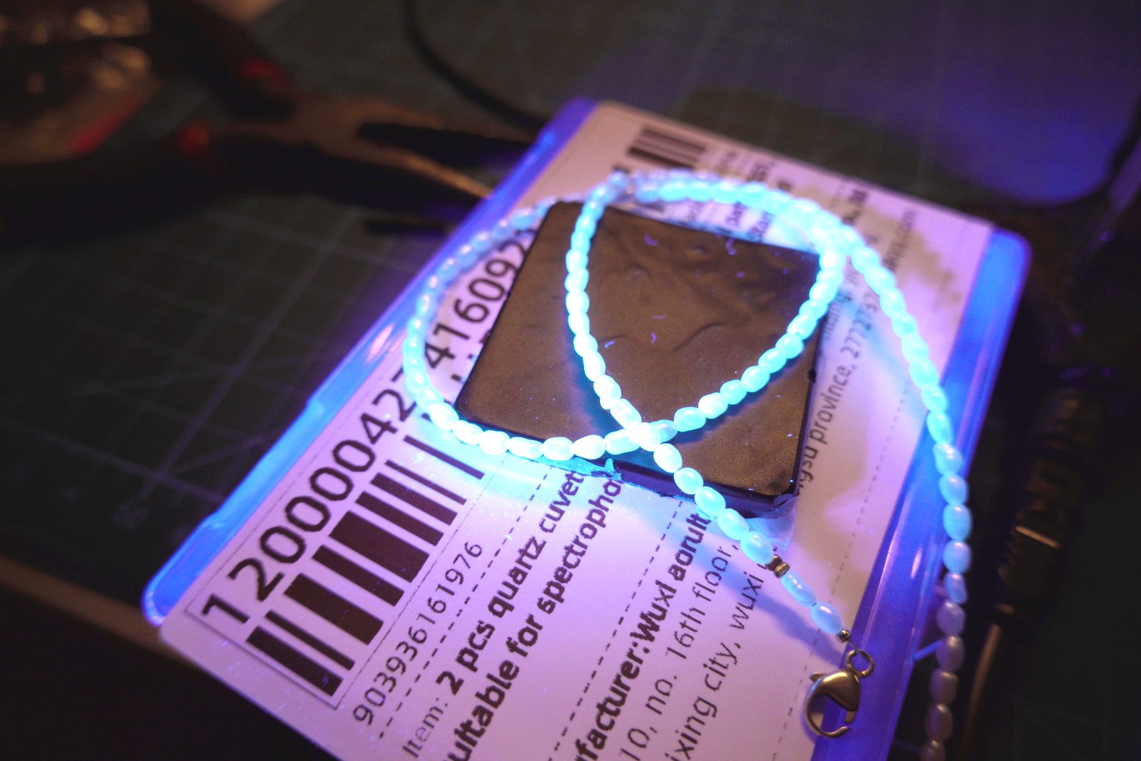 Blue-white fluorescent bead necklace under UV