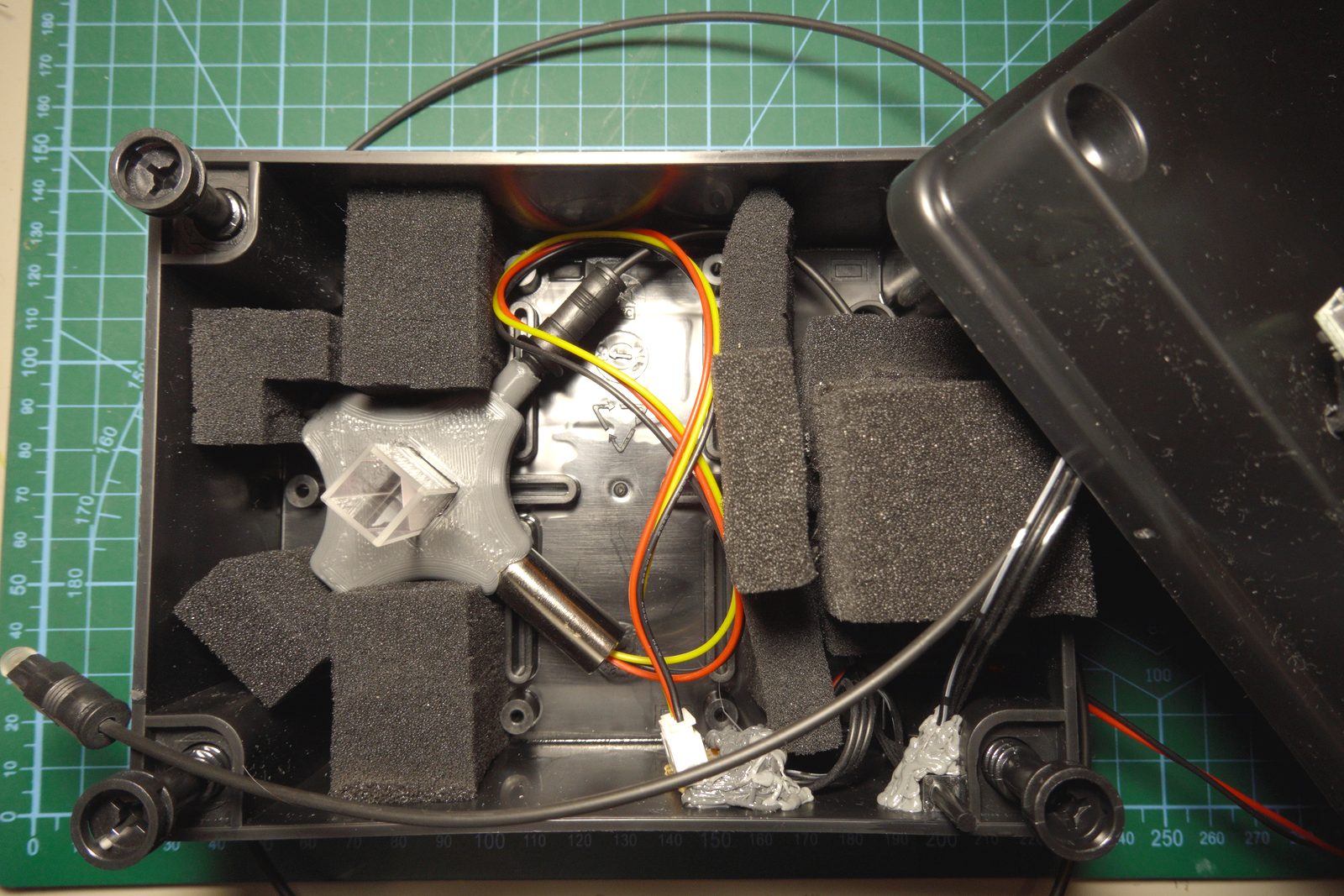 Interior of the UV fluorescence measurement box — foam-lined project enclosure with UV LED, cuvette holder assembly, and fiber cables