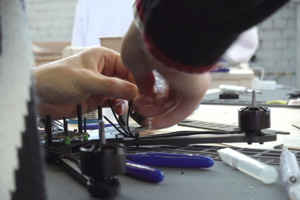 Hands-on build session at Dronefix.lt — wiring a drone frame on a workbench