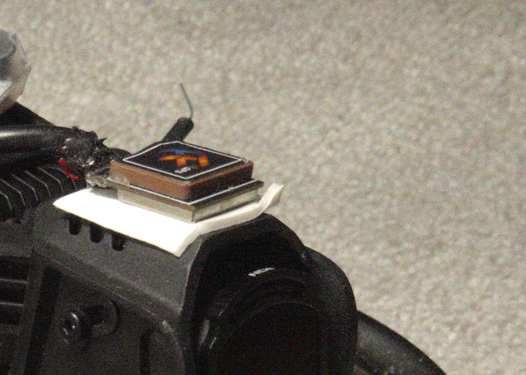 GPS module mounted on top of the DJI O4 Pro camera housing — patch antenna and shielded cable visible